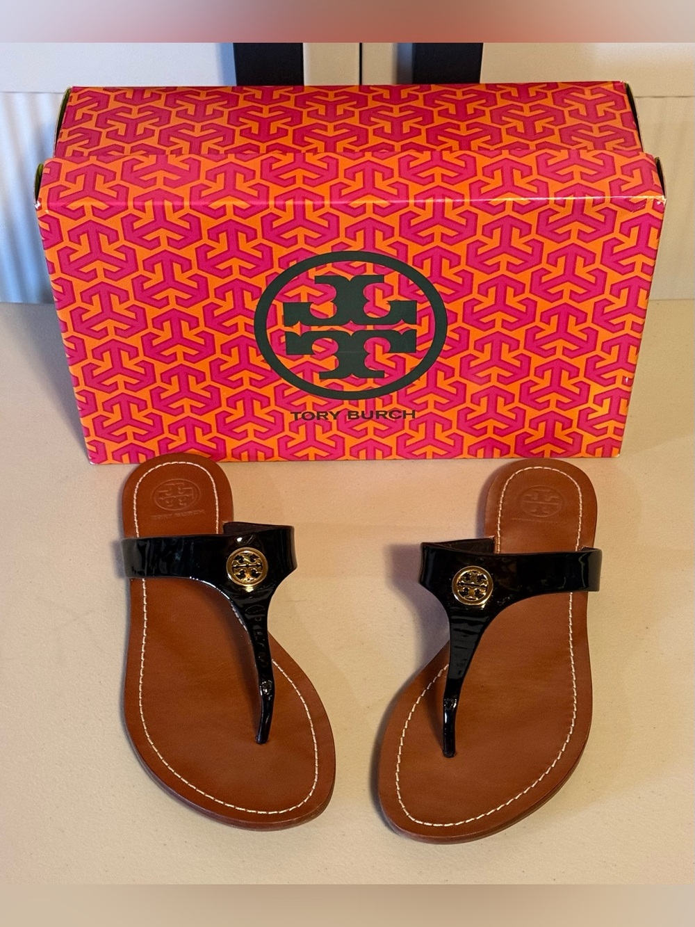 Tory Burch “Cameron” Black Patent Gold-Tone Medallion Logo Thong Sandals